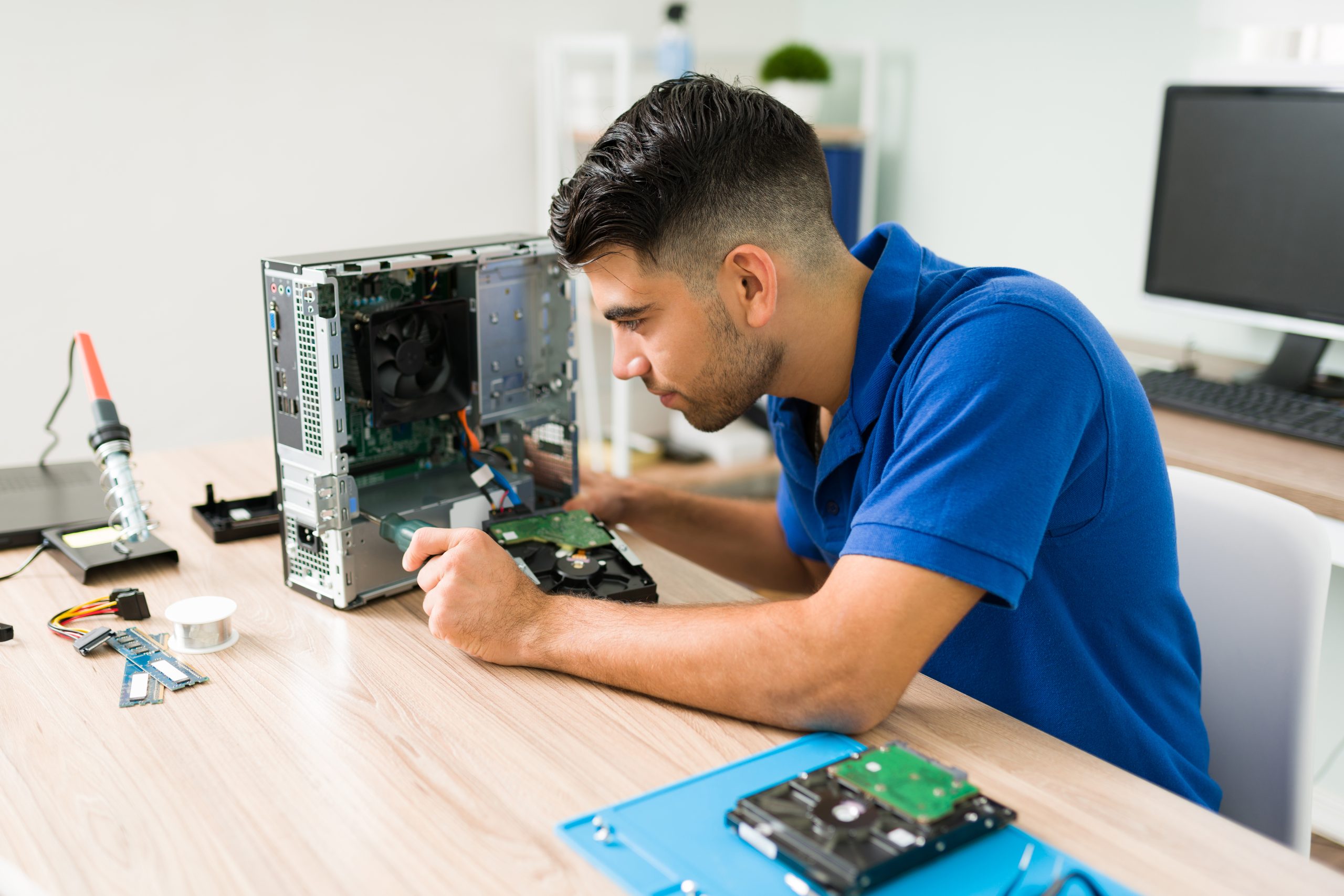 I need to fix this. Young man using a screwdriver to look inside a broken CPU computer before repairing at the shop